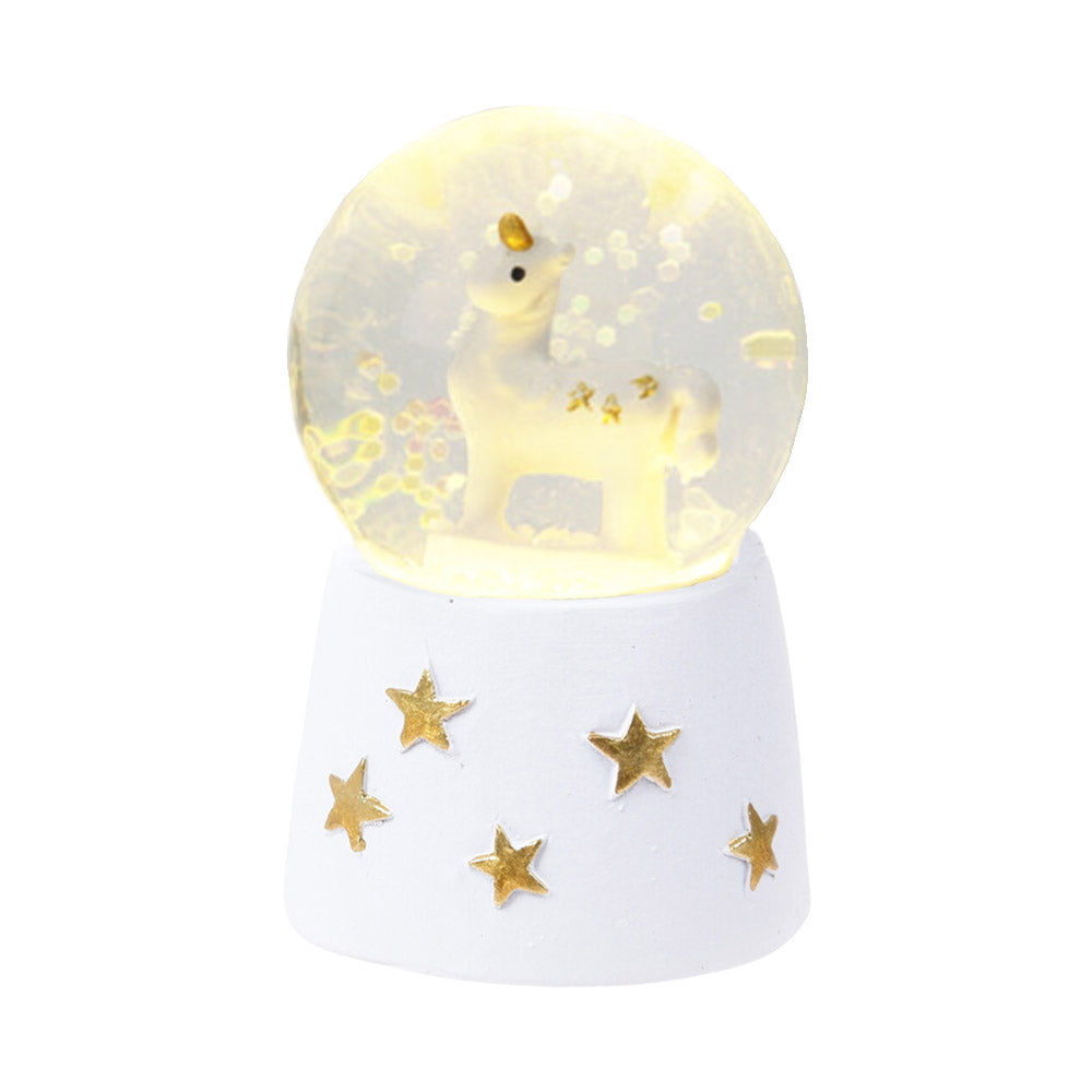 Bola de agua con forma de bola de nieve con unicornio sobre base blanca con estrellas doradas y LED blanco cálido